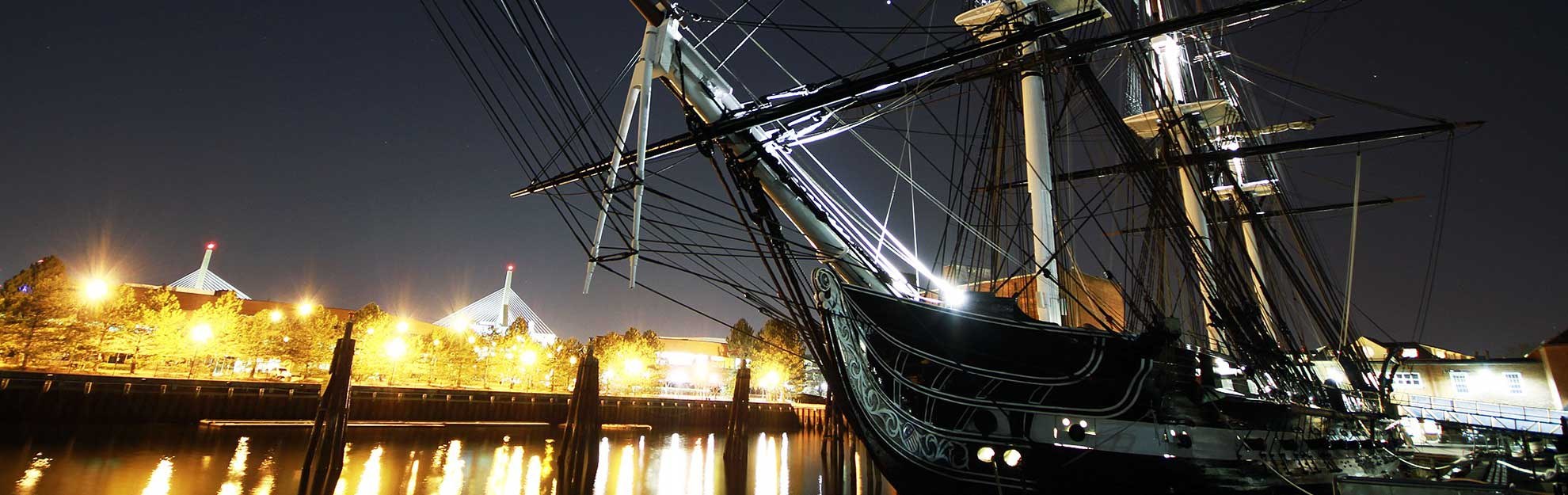 USS Constitution at the Boston harbour quay at night.